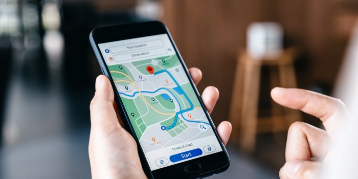hand of young woman searching location in map online on smartphone