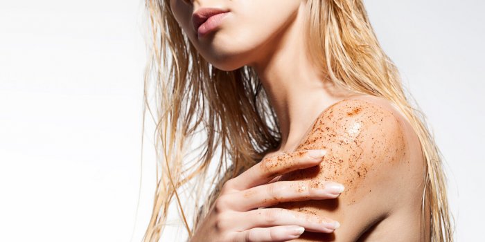 close-up of a woman's shoulder with scrub of coffee