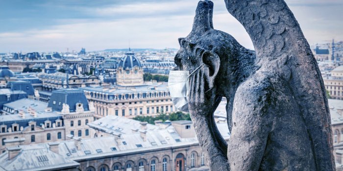 covid-19 coronavirus in france, medical mask on gargoyle of notre dame in paris tourist landmarks closed due to corona vi...