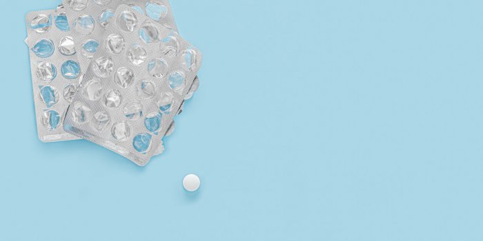 last pill empty pill packaging drug shortage deficiency concept empty packs of pills and last pill isolated on blue backg...